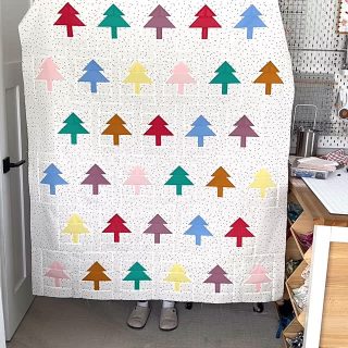 I really embraced those Scandinavian vibes for this modified version of the #treerowsquilt.  I went with a solid polka dot for the background instead of multiple colored rows and an assortment of tree colors.  You can find the quilt pattern in my shop. #christmasquilt #treequilt #quiltylove #quiltylovepatterns #holidayquilt #swedishholiday