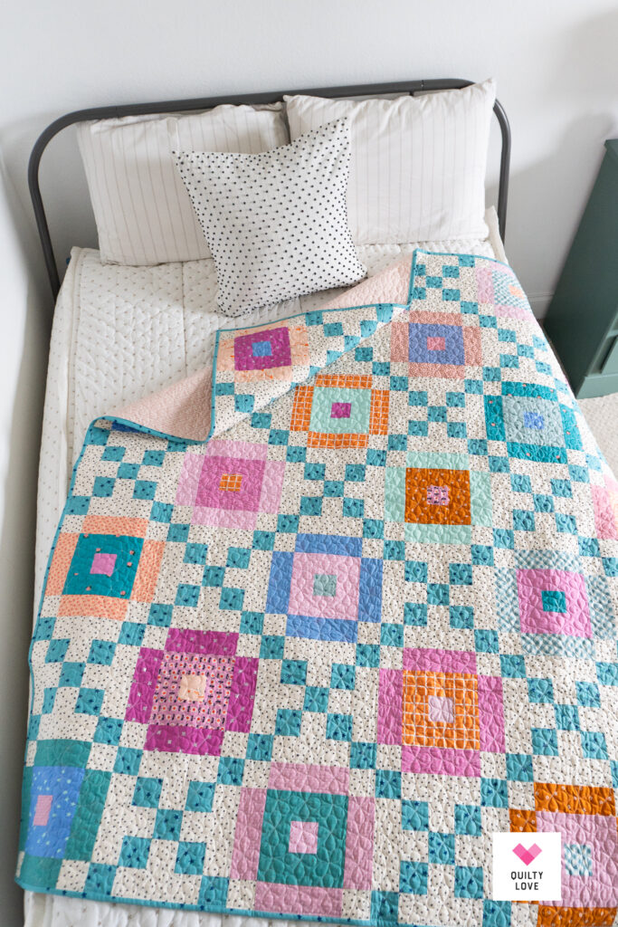 A Lucky Links quilt on a bed with a Beddy's quilt set.
