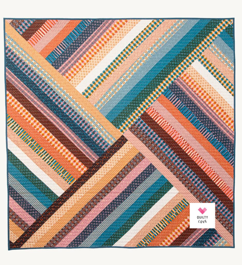 Vibrant quilt with geometric patterns and bright colors from Quilty Love.