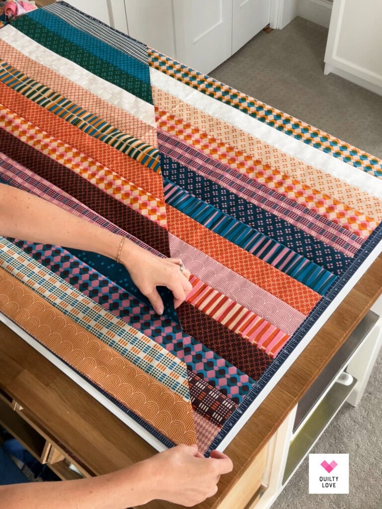 Vibrant patchwork quilt with various patterns and colors on a table.