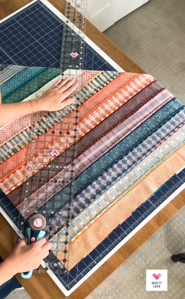 Colorful quilt fabrics arranged on cutting mat for quilting project.