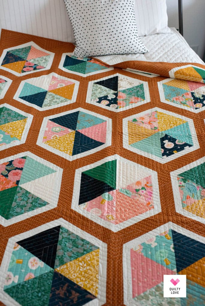 A Triangle Hexies quilt on a bed