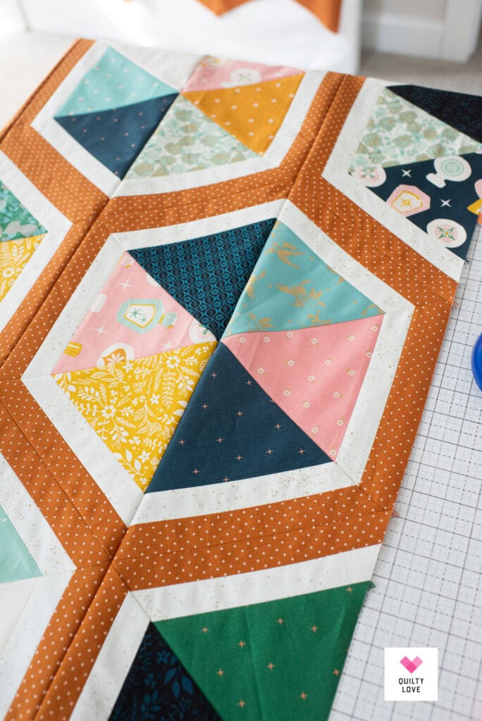 A close up of a Triangle Hexies quilt top on a cutting mat