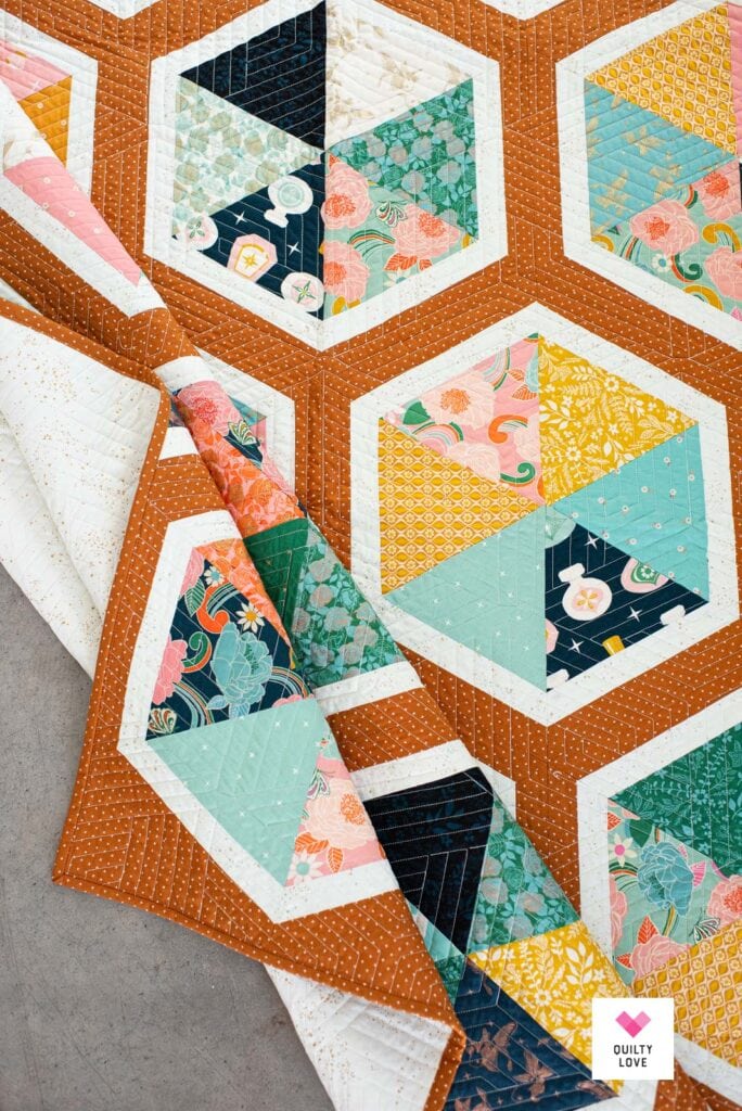 A Triangle Hexies quilt showing the front, back and binding